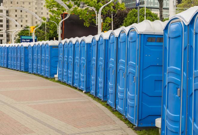 a row of portable restrooms at an outdoor special event, ready for use in Austell